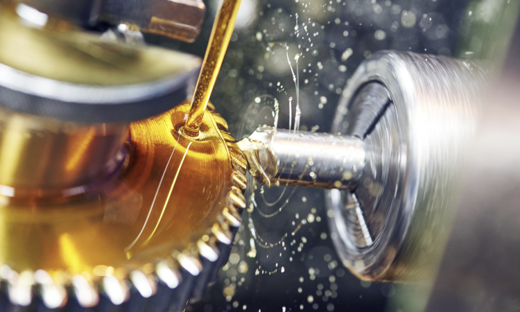 Se aplica aceite lubricante de color dorado a un componente industrial